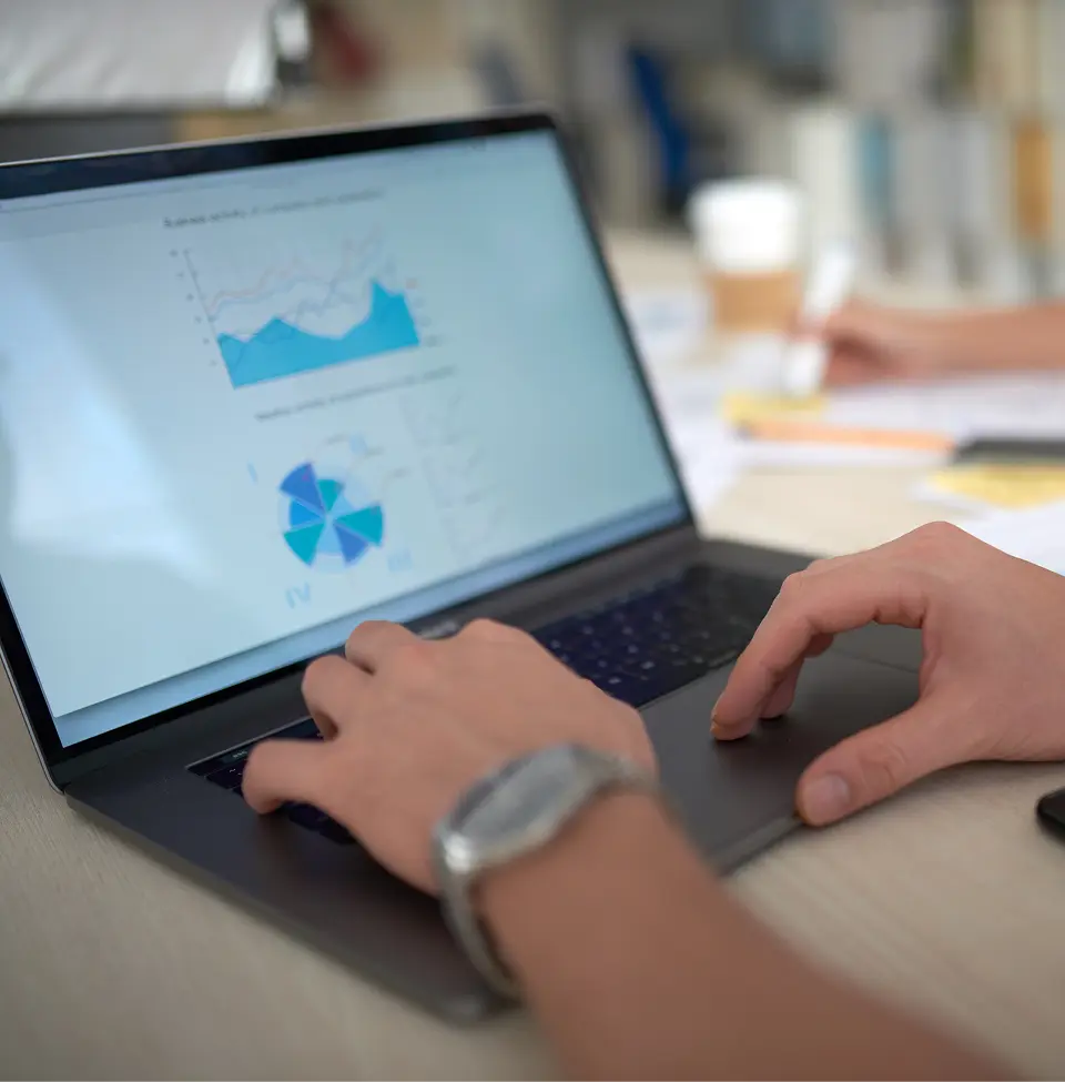 shoulder-view-laptop-screen-showing-financial-stat-visuals 1